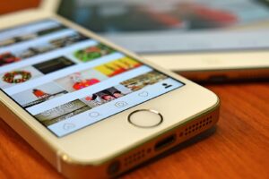 Vue rapprochée d'un smartphone affichant l'application Instagram sur une surface en bois.